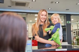 mom holding her child at the dentist’s front desk