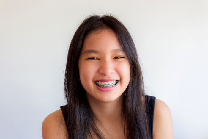 A smiling teenage girl with braces.